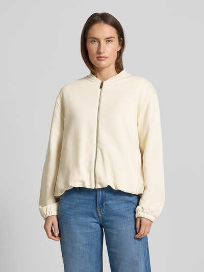 Modelka kobieca nosi Boxy Fit Jacke aus Baumwoll-Mix od s.Oliver RED LABEL, kremowa tkanina, długi rękaw, elastyczne wykończenia, całkowity widok z przodu.