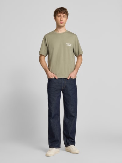 Mannenmodel draagt T-shirt met statementprint model 'NORREBRO' van Jack & Jones, puur katoen, recht model, ronde hals, ruglengte maat M 68 cm, voorkant hele lichaam