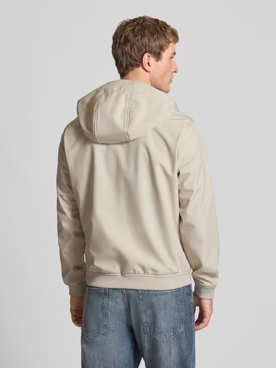 Männermodel trägt Softshelljacke mit Reißverschlusstaschen von Jack & Jones in Beige, Regular-Fit, Kapuze mit Tunnelzug, Rückenansicht. Rückenlänge bei Größe M: 59 cm, Schulterbreite: 39 cm, Brustweite: 48 cm, Ärmellänge: 62 cm.