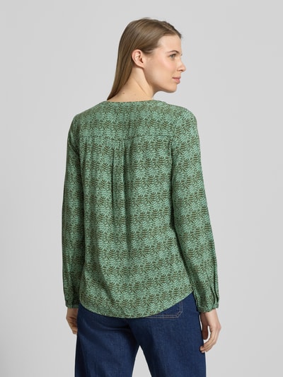 Frauenmodel trägt Regular Fit Schlupfbluse aus reiner Viskose von Christian Berg Woman mit floraler Allover-Print, grün, langärmelig, Tunika-Kragen, Ganzkörperansicht Rückansicht.