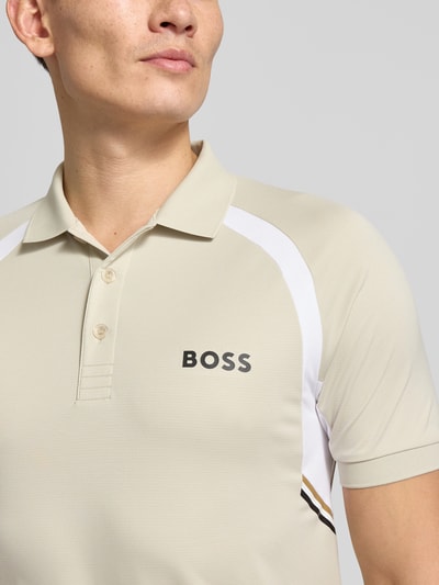 Männermodel trägt Slim Fit Poloshirt mit kurzer Knopfleiste Modell 'PL_TOC SPIN CB' von BOSS Green, unifarben, Nahaufnahme Oberkörper.
