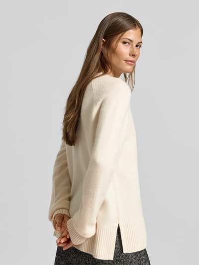 Frauenmodel trägt Regular Fit Pullover aus reinem Kaschmir in Strick-Optik von MYON, cremefarben, dezente Struktur, Ganzkörperansicht Rückansicht.