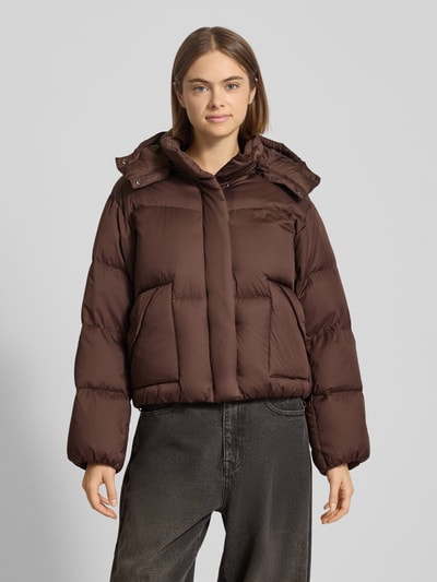 Modelka kobieca nosi Regular Fit Steppjacke mit Kapuze Modell 'Bubble' od Levi's®, brązowa, pikowana, z kieszeniami, kaptur, widok z przodu całej sylwetki.