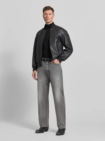 Męskamodel nosi czarny Rollkragenpullover aus Merinowolle Modell 'TRAY' von SELECTED HOMME, krój slim fit, drobno prążkowane wykończenia, dzianina, przód, całopostaciowe ujęcie.