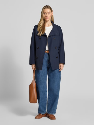 Modelka kobieca ma na sobie Regular Fit Jacke mit Stehkragen od Christian Berg Woman Selection, mieszanka bawełny, krój regular fit, stójka, listwa guzikowa 2-rzędowa, wpuszczane kieszenie, długość tyłu w rozmiarze 36: 68 cm, szerokość ramion w rozmiarze 36: 39 cm, szerokość klatki piersiowej w rozmiarze 36: 50 cm, długość rękawów w rozmiarze 36: 63 cm, kolor granatowy, tekstura gładka, widok całej sylwetki z przodu.