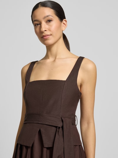 Frauenmodel trägt Cocktailkleid aus Leinen-Viskose-Mix Modell 'Celina' von Forever New in Braun, A-Linie, 2-in-1-Look, Nahaufnahme Oberkörper. Rückenlänge bei Größe 36: 31 cm, Brustweite bei Größe 36: 41 cm.