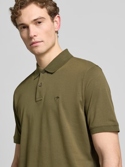 Männermodel trägt Regular Fit Poloshirt mit Logo-Stitching von Fynch-Hatton in Olivgrün, reine Baumwolle, Nahaufnahme Oberkörper.