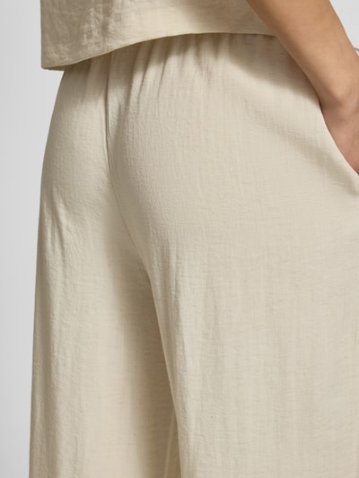 Frauenmodel trägt Straight Fit Hose aus Viskose-Mix Modell 'Daria' von MSCH Copenhagen in Beige mit Leinen-Viskose-Anteil, Nahaufnahme Rückansicht.