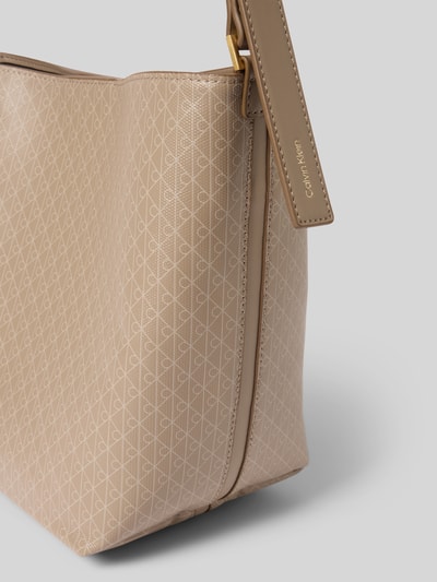 Produktfoto, Bucket Bag in Leder-Optik von CK Calvin Klein, beige mit Allover-Logo-Print, Logo-Prägung, glatte strukturierte Oberfläche, Nahaufnahme, Hauptfach mit Magnetverschluss, verstellbarer Schulterriemen, herausnehmbare Innentasche mit Reißverschluss, Maße: 27x25x12 cm, Länge Schulterriemen 50 cm.