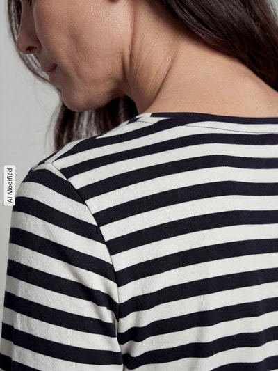 Frauenmodel trägt Longsleeve mit Rundhalsausschnitt und 3/4-Arm von Christian Berg Woman, reine Baumwolle, feine Streifenoptik, Detailaufnahme Schulter und Rücken.