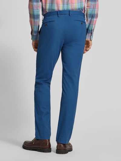Männermodel trägt Slim Fit Chino aus Baumwoll-Mix von Polo Ralph Lauren, Optik: Unifarben, Passform: Slim-Fit, Länge: Regular, Label-Stitching-Applikation, Gürtelschlaufen, Knopf und verdeckter Reißverschluss, 5-Pocket-Design, Material: Baumwoll-Mix, kräftiges Blau, glatte Textur, Ganzkörperansicht Rückansicht.