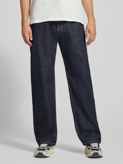 Mannenmodel draagt Baggy Fit Jeans met steekzakken van REVIEW in donkerblauw, zuiver katoen, vooraanzicht vollichaam.