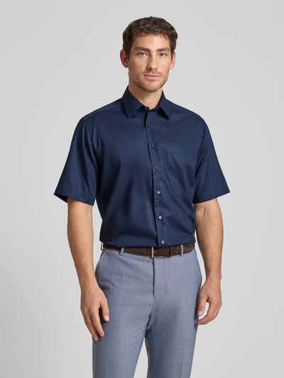 Männermodel trägt Comfort Fit Business-Hemd aus Baumwolle mit Kentkragen von ETERNA in Dunkelblau, glatte Textur, Ganzkörperansicht von vorne, Reine Baumwolle, 1/2-Arm, Rückenlänge 80 cm, Schulterbreite 47 cm, Ärmellänge 33 cm.