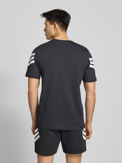 Männermodel trägt Regular Fit T-Shirt aus reiner Baumwolle von adidas Sportswear, unifarben mit Logo-Print, Ganzkörperansicht Rückansicht.