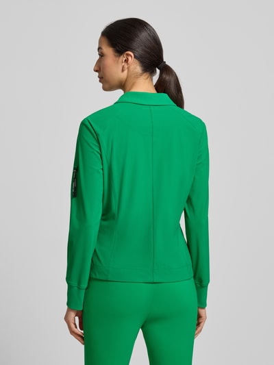 Modelka kobieca nosi Blazer mit Knopfverschluss od Marc Cain, zielony, materiał z domieszką stretchu, krój slim fit, widok całej sylwetki z tyłu. Szerokość w rozmiarze 36: 48 cm, długość z tyłu: 57 cm, długość rękawa: 61 cm, kieszenie z wypustką, kołnierz z klapami.