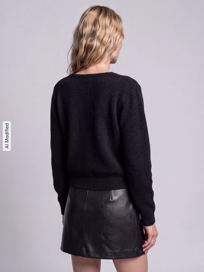 Frauenmodel trägt Relaxed Fit Strickjacke mit Wool-Anteil Modell 'LIVA' von ONLY, schwarze Farbe, Damen Strickjacke, Ganzkörperansicht Rückansicht, KI-modifiziertes Bild.
