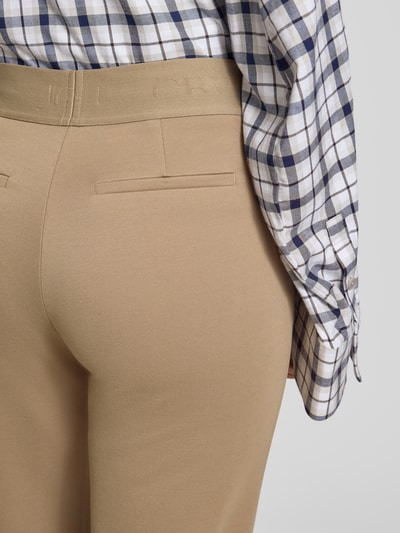 Frauenmodel trägt Stoffhose mit elastischem Bund von Christian Berg Woman in Beige mit Gesäßtaschen, Detailaufnahme Rückansicht.