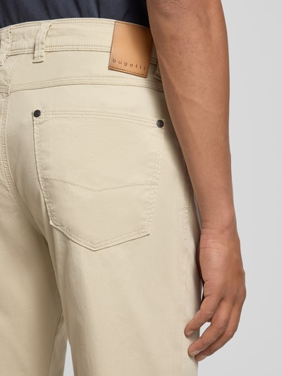 Männermodel trägt Hose im 5-Pocket-Design Modell 'CORDOBA' von bugatti aus beigefarbenem Baumwoll-Mix mit Stretch, Detailaufnahme Rückansicht.