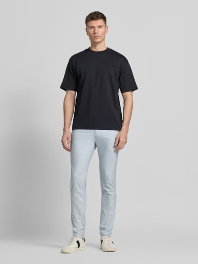 Mannelijk model draagt Slim Fit Chino uit katoenmix met linnen en viscose-aandeel model 'Chino-Slim-2' van BOSS Orange, denimlook in lichtblauw met mid waist, label patch en knoop-ritssluiting, zij- en achterzakken, twillstructuur, geheel vooraanzicht.