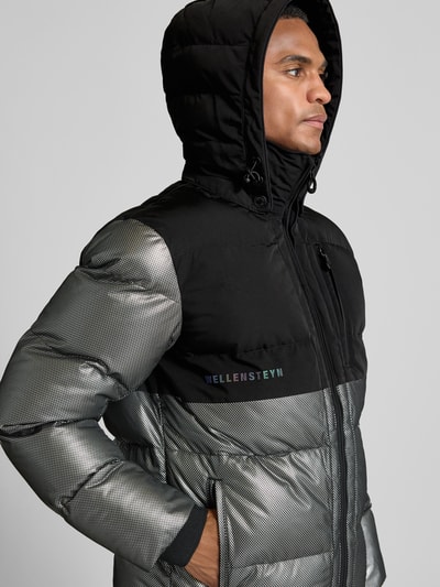 Männermodel trägt Regular Fit Steppjacke mit Stehkragen Modell 'ROYAL FLASH' von Wellensteyn in reflektierender Optik, Nahaufnahme Oberkörper.