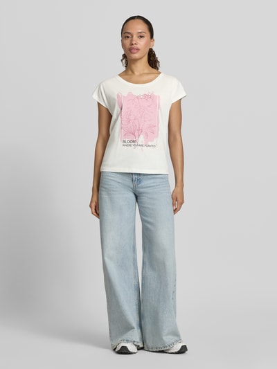 Frauenmodel trägt Regular Fit T-Shirt aus Viskose-Mix mit Floraler-Print von Christian Berg Woman, Creme mit Rosa, Ganzkörperansicht von vorne. Damen T-Shirt, Rundhalsausschnitt, Rückenlänge bei Größe S 55 cm, glatte Oberfläche.