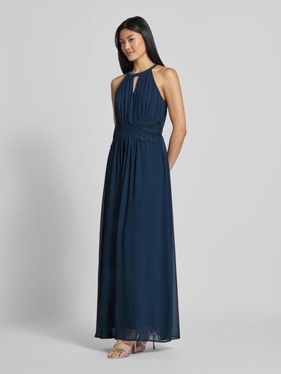 Vrouwenmodel draagt avondjurk met tailleband Model 'MILINA' van VILA in donkerblauwe chiffon, getailleerd model, Maxi-jurk, halter, druppelvormige hals, tailleband, ruglengte maat 36: 146 cm, borstwijdte maat 36: 35 cm, geheelopname vooraan.