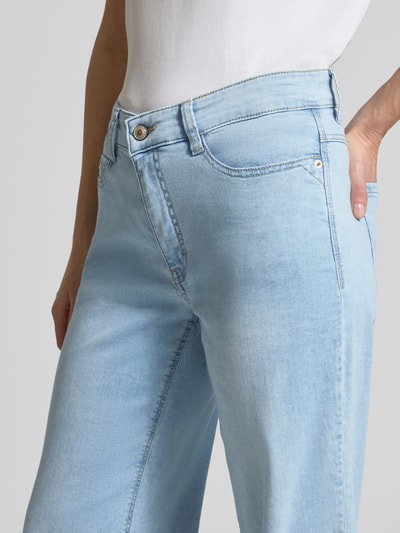 Kobiece model prezentuje Wide Leg Jeans mit Eingrifftaschen Modell 'Dream' od MAC, mieszanka bawełny i modalu, jasnoniebieski, wpuszczane kieszenie, szerokość w rozmiarze 36/32: 38 cm, długość wewnętrzna nogawki: 83 cm, detal ujęcie z przodu.