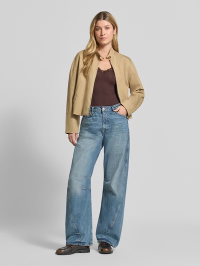 Kobiece modelka nosi Slim Fit Tanktop aus Viskose-Mix Modell 'ROSA' von VERO MODA w kolorze brązowym, szerokie niebieskie dżinsy, beżowa kurtka, prosta tekstura, widok całej sylwetki z przodu, top damski