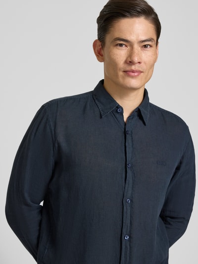 Männermodel trägt Regular Fit Freizeithemd aus reinem Leinen Modell 'RELEGANT' von BOSS Orange, dunkelblau, Optik: Unifarben, Nahaufnahme Oberkörper.