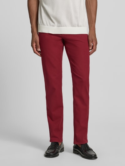 Mannenmodel draagt Slim Fit Jeans im 5-Pocket-Design van Christian Berg Men in bordeaux, katoenmix, knoop- en ritssluiting, slim fit, 5-pocketmodel, bandwijdte 42 cm, binnenbeenlengte 82 cm, vooraanzicht volledige lichaamsfoto.