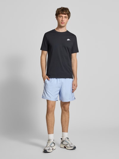 Männermodel trägt Shorts mit Label-Stitching und elastischem Bund von Nike in Hellblau, Regular-Fit, Ganzkörperansicht von vorne. Herren Shorts mit Tunnelzug, Bundweite bei Größe M 41 cm, Innenbeinlänge 14 cm.