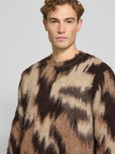 Männermodel trägt Regular Fit Strickpullover mit Lanawoll-Anteil Modell 'Forrest' von Les Deux in Braun- und Beigetönen, Nahaufnahme Oberkörper. Herren Strickpullover mit elastischem Material-Mix, gerippten Abschlüssen, langärmeligem Design und Rundhalsausschnitt.