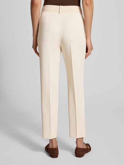 Frauenmodel trägt Hose mit elastischem Bund und Bügelfalten Modell 'Philomena' von JOOP! in Beige, verkürzte Passform, Ganzkörperansicht Rückansicht.