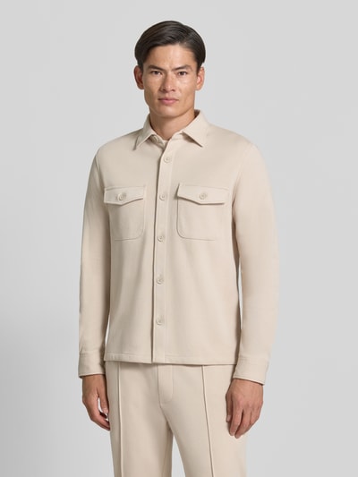 Männermodel trägt Overshirt mit Knopfleiste von MCNEAL in Beige, Material-Mix mit Baumwoll-Anteil, Brusttaschen, gerader Schnitt, Nahaufnahme Oberkörper.