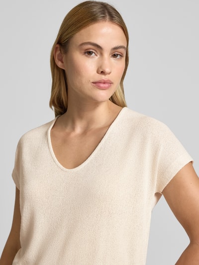 Vrouwenmodel draagt T-shirt uit viscosemix met V-hals model 'SIRUKUS' van OPUS in relaxed fit, crème, fijne textuur, nahaufnahme bovenlichaam.