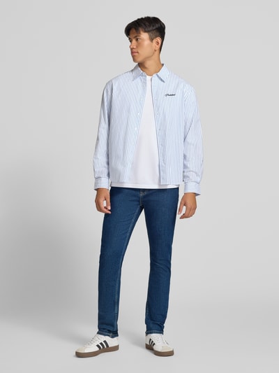 Männermodel trägt Slim Fit Jeans aus Baumwoll-Mix Modell 'Hatch' von Pepe Jeans in Dunkelblau, Herren Slim Fit Jeans von Pepe Jeans, Ganzkörperansicht von vorne.