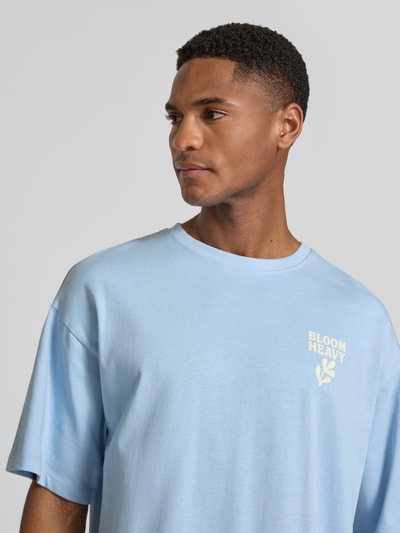 Männermodel trägt Relaxed Fit T-Shirt mit Statement-Print Modell 'RUDE' von Casual Friday in Hellblau, reine Baumwolle, Nahaufnahme Oberkörper.