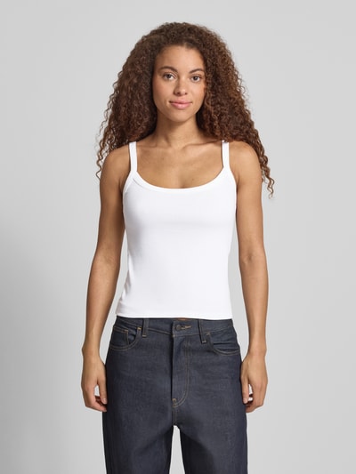 Frauenmodel trägt weißes Slim Fit Tank Top aus Bio-Baumwoll-Mix Modell 'MAY' von Pieces, schmale Träger, Feinripp, Ganzkörperansicht von vorne.