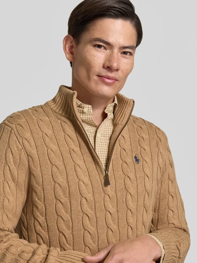 Männermodel trägt Relaxed Fit Troyer aus reiner Baumwolle von Polo Ralph Lauren in Beige mit Zopfmuster, Nahaufnahme Oberkörper.