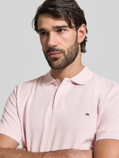 Mężczyzna nosi Regular Fit Poloshirt mit Stitching od Christian Berg Men z bawełny, listwą guzikową, haftem, kolor jasnoróżowy, zbliżenie na górną część ciała.
