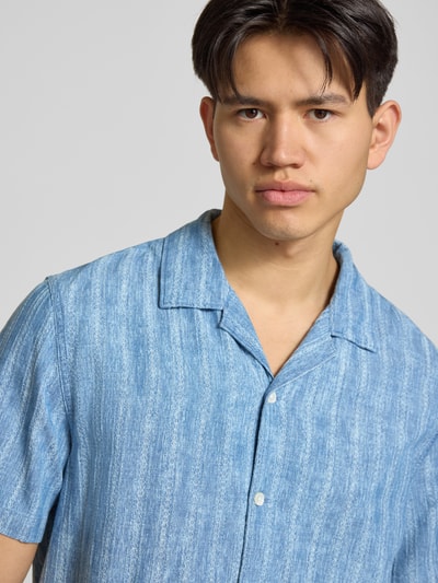 Męski model nosi Regular Fit Freizeithemd aus reiner Baumwolle Modell 'SUNSET CAMP' od Levi's®, denim, faktura dobby, aplikacja z metką, kołnierzyk koszulowy, krótki rękaw, wykończenie boczne, bawełna, zapięcie na guziki, zbliżenie na górną część ciała