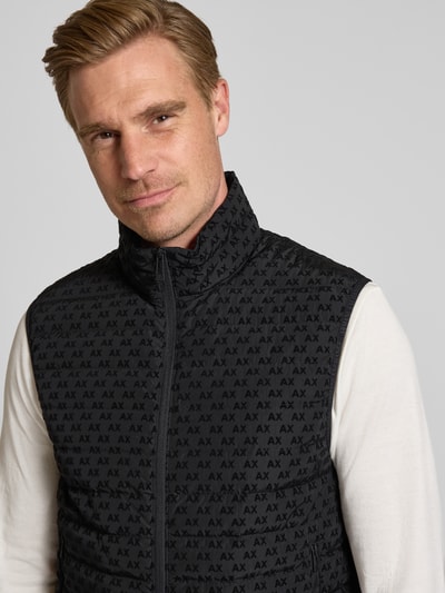 Männermodel trägt Regular fit heren bodywarmer met vulling van eendendons en veren Model 'PIUMINO' van Armani Exchange, All-over logoprint, Opstaande kraag, tweewegritssluiting, Ruglengte maat M 67 cm, Schouderbreedte 46 cm, Borstwijdte 54 cm, Nahaufnahme Oberkörper.