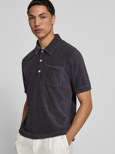 Männermodel trägt Regular Fit Poloshirt aus Baumwoll-Mix von Closed, Nicki-Struktur, Polokragen, Brusttasche, Ganzkörperansicht von vorne.