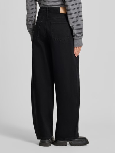 Männermodel trägt Barrel Fit Jeans mit Eingrifftaschen Modell 'Cindy Draciel' von MOS MOSH, mieszanka bawełny i elastanu, czarny kolor, szerokość w rozmiarze 27: 38 cm, długość wewnętrzna nogawki w rozmiarze 27: 78 cm, wpuszczane kieszenie, widok całej sylwetki z tyłu.