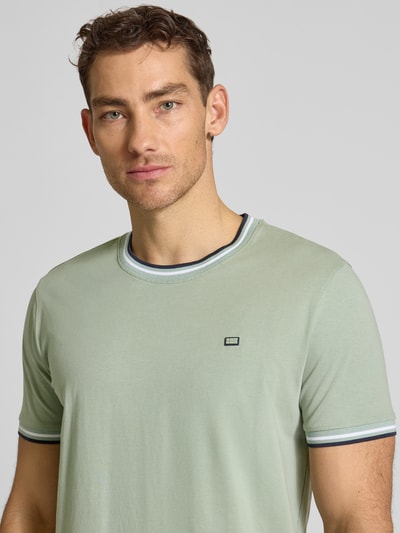 Männermodel trägt T-Shirt mit Kontraststreifen und Rundhalsausschnitt von Christian Berg Men aus Baumwoll-Elasthan-Mix, Regular-Fit, Nahaufnahme Oberkörper.