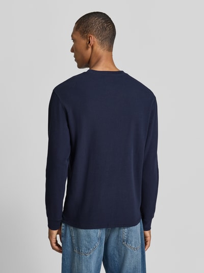 Männermodel trägt Regular Fit Sweatshirt aus reiner Baumwolle von Scotch & Soda in Dunkelblau mit Strukturmuster, Ganzkörperansicht Rückansicht.