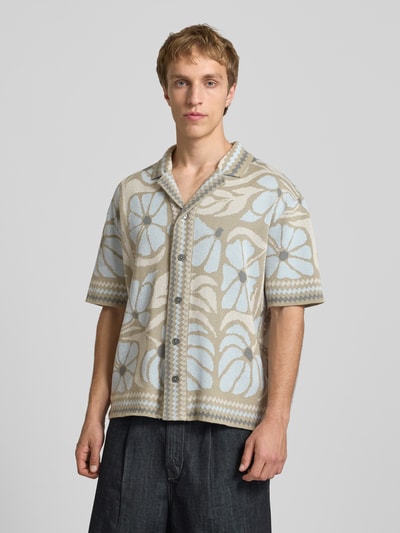 Männermodel trägt Relaxed Fit Freizeithemd aus Baumwoll-Mix Modell 'DUKE' von Only & Sons im mehrfarbigen, floral gemusterten Design, Resortkragen, Kurzarm, Ganzkörperansicht von vorne.