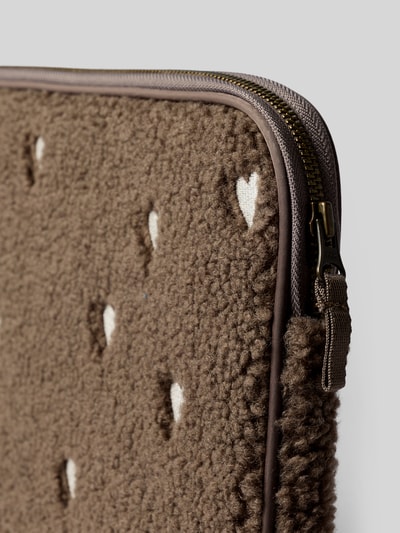 Produktfoto, Laptoptasche mit Logo-Patch von Studio Noos, braunes Teddyfell mit Allover-Motiv-Stitching, Reißverschluss, Detailaufnahme.