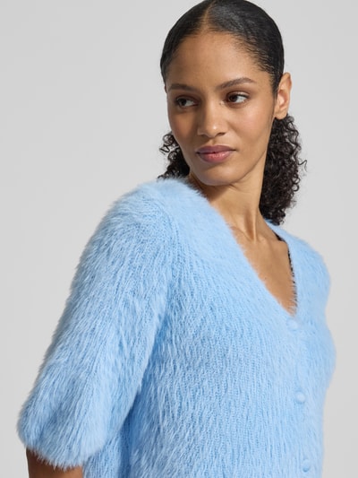 Modelka kobieca nosi Regular Fit Jacke in Strick-Optik od Jake*s Cocktail, niebieska, z dekoltem w serek, z guzikami, krój regular fit, długość tyłu w rozmiarze 36: 47 cm, ujęcie z przodu, zbliżenie na górną część ciała.