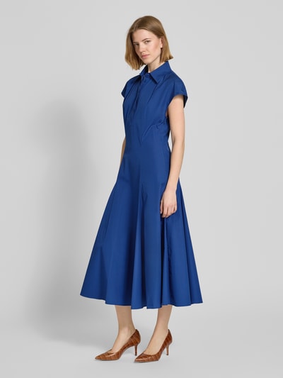 Frauenmodel trägt ausgestelltes Freizeitkleid aus reiner Baumwolle Modell 'GIORNO' von MAX&Co., unifarbenes Blau, florales Muster, Midi-Länge, Popeline, Ganzkörperansicht von vorne.